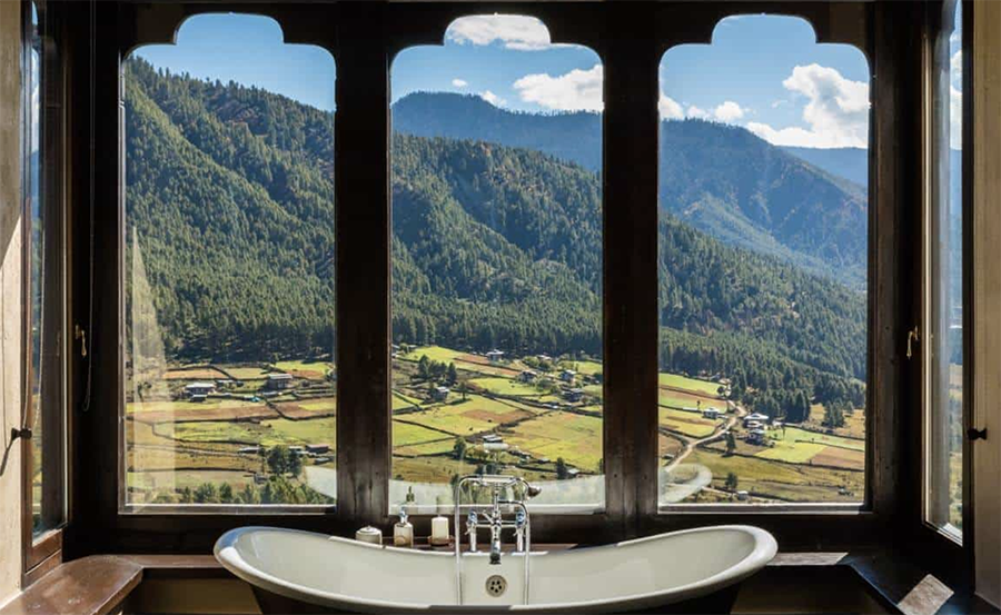 Modernes Badezimmer in der Gangtey Lodge mit Badewanne und Fenster zur natürlichen Umgebung