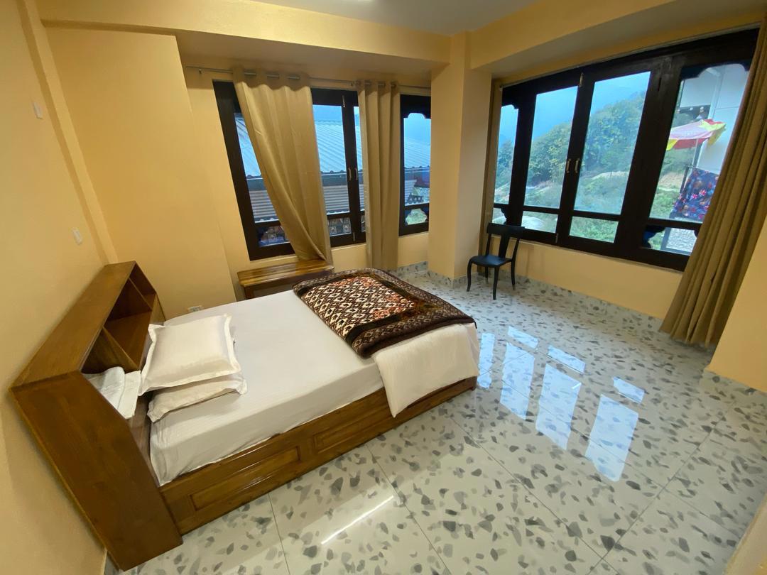 Geräumiges Einzelzimmer mit großen Fenstern im Wangjur Hotel, Pema Gatshel