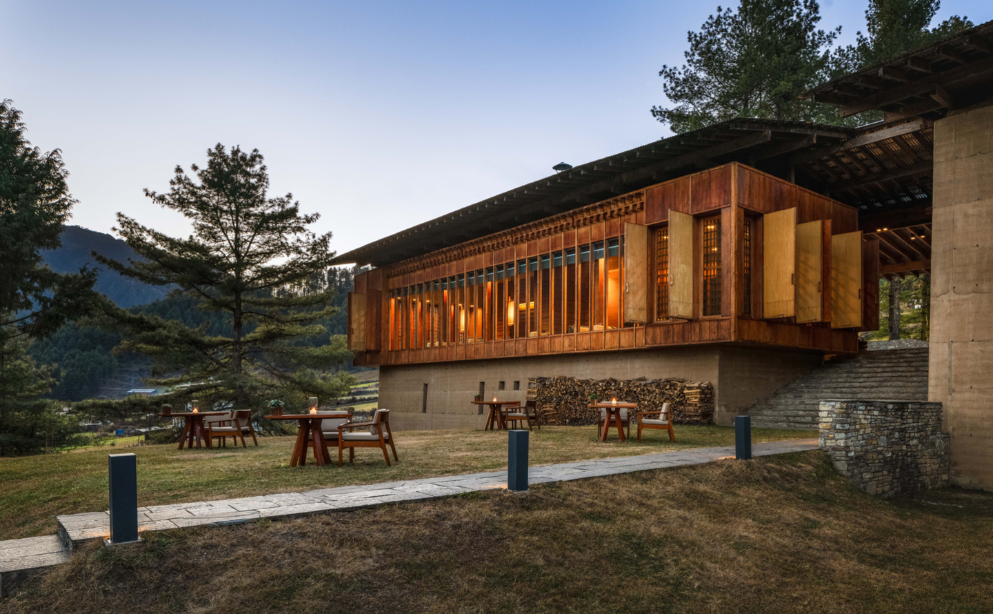 Blick auf die Amankora Gangtey Lodge eingebettet in grüne Hügel des Phobjikha-Tals.