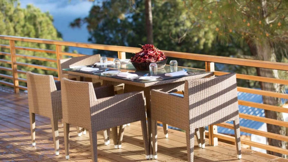 Außenbereich mit Essplatz auf Holzterrasse, umgeben von Natur, ideal für Frühstück mit Talblick.