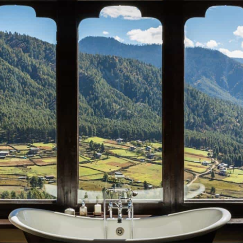 Modernes Badezimmer in der Gangtey Lodge mit Badewanne und Fenster zur natürlichen Umgebung