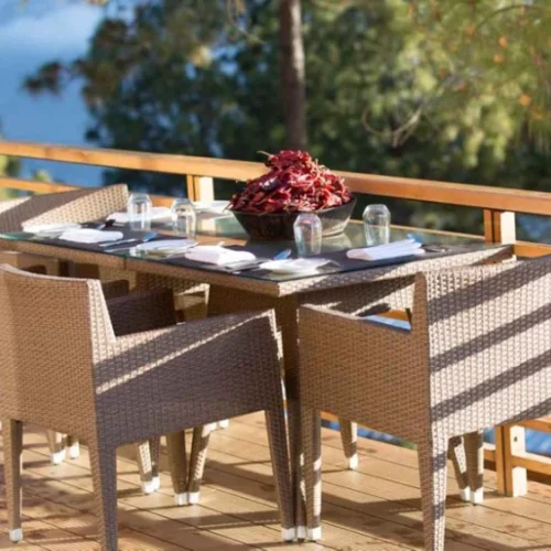 Außenbereich mit Essplatz auf Holzterrasse, umgeben von Natur, ideal für Frühstück mit Talblick.